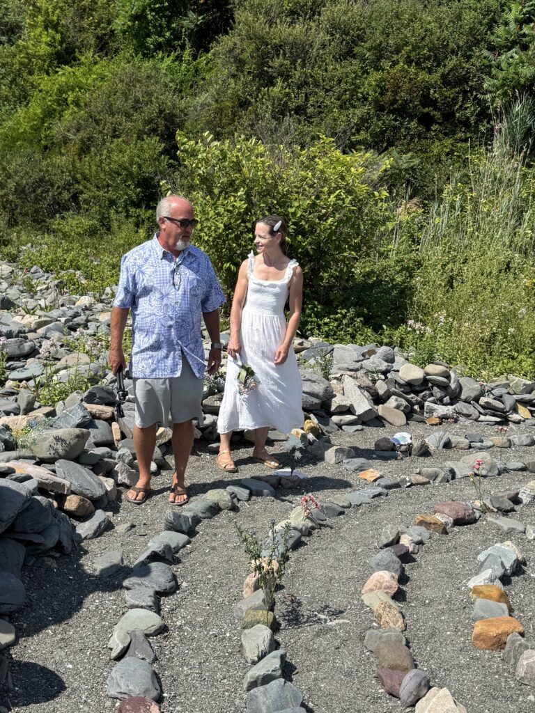 Two visitors standing at the entrance path of the stone labyrinth